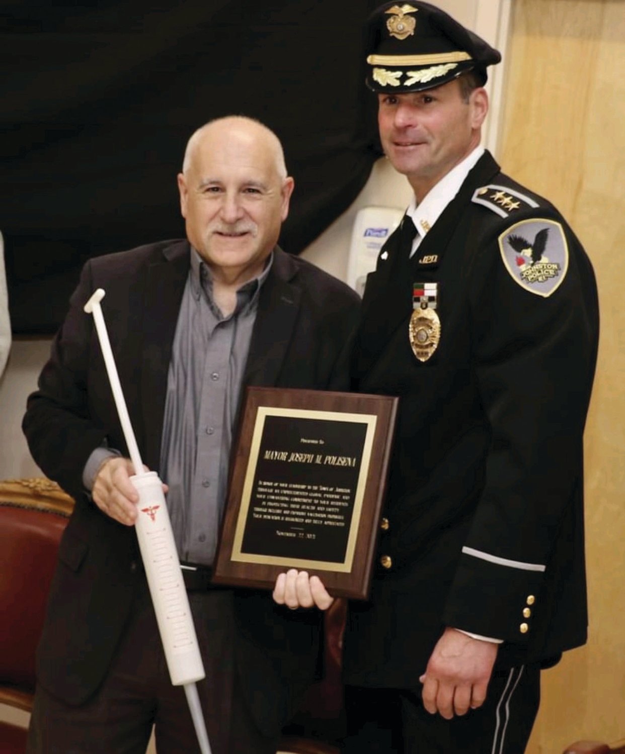 AWESOME AWARDS: Johnston Mayor Joseph M. Polisena in all smiles after receiving two awards - an inflated syringe and the JPD’s Civilians Award for Meritorious Acts - from Police Chief Joseph Razza during the recent Recognition of Excellence Ceremony.